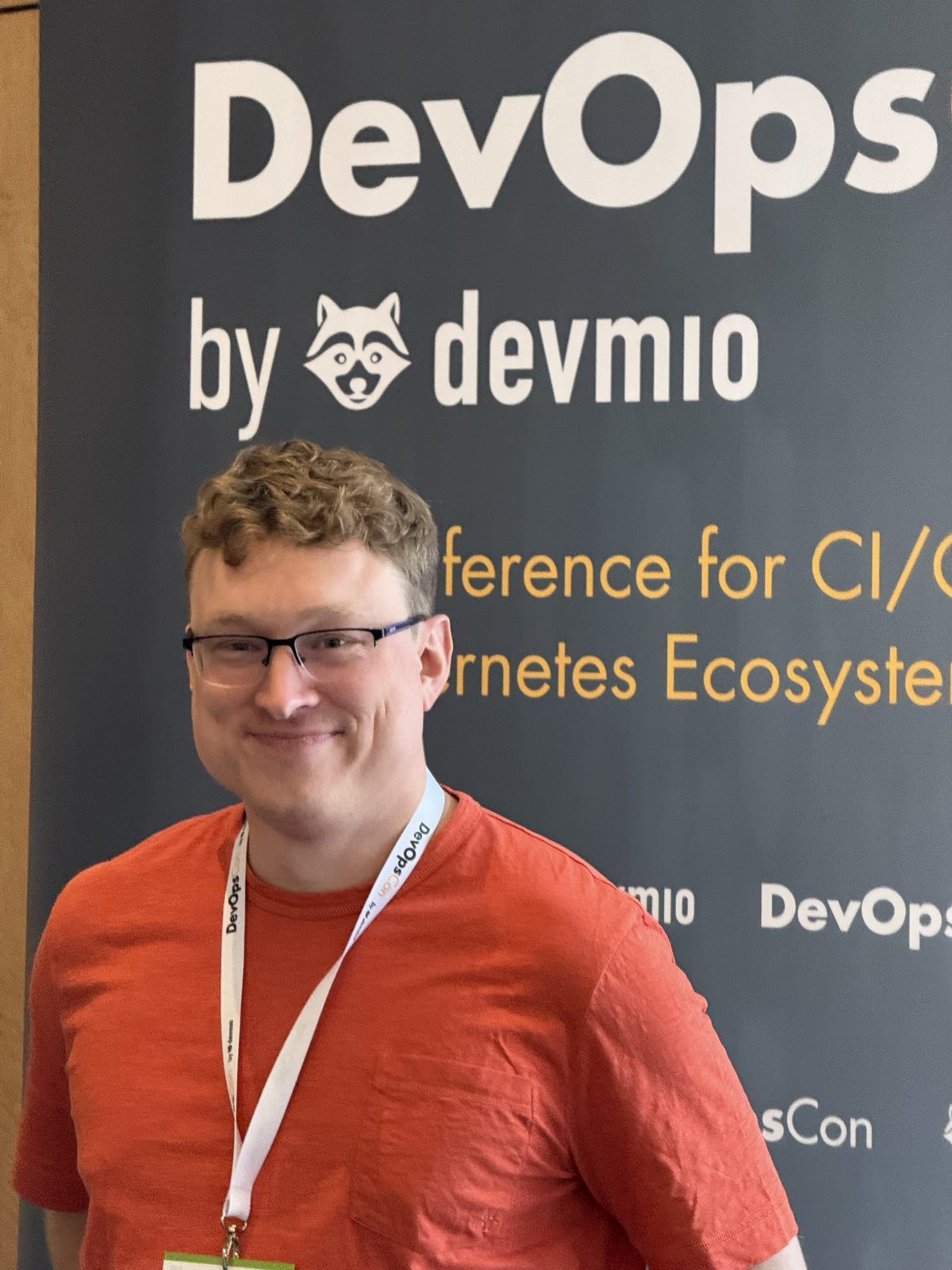Karsten Sitterberg vor einer DevOpsCon-Stellwand